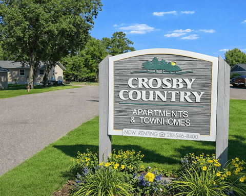 A sign for Crosby Country Apartments and Townhomes with a phone number for renting.