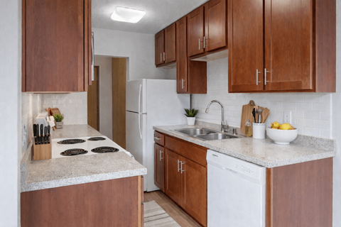 A kitchen with brown cabinets and a white fridge.