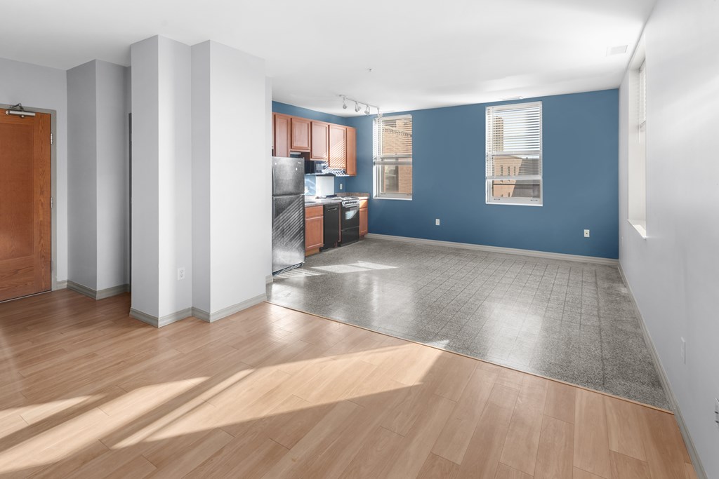 A room with a kitchen area and a dining table.