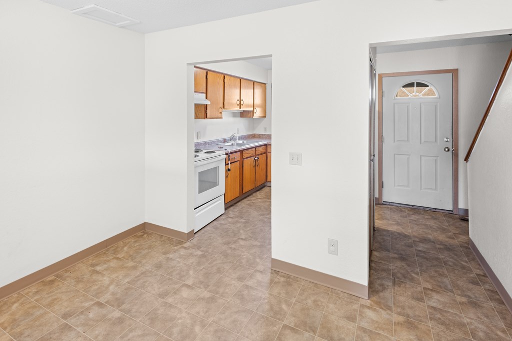 A kitchen with white walls and a tiled floor.