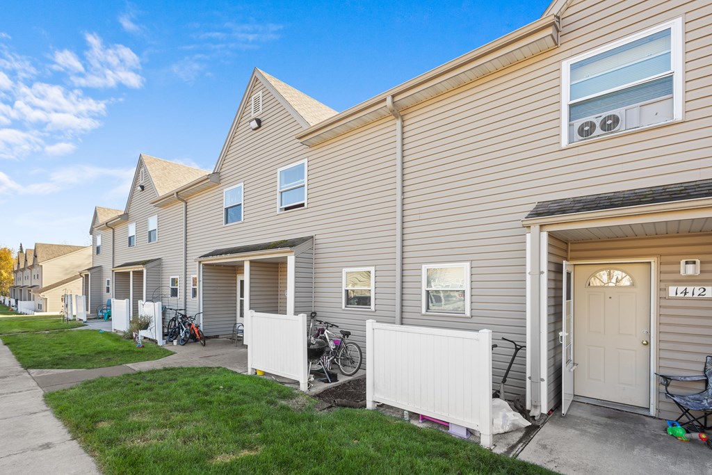 A row of houses with garages and bicycles parked outside.