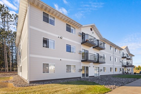 A modern apartment building with balconies and a clear blue sky.