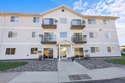 A two-story apartment building with a balcony on the second floor.