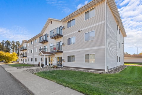 A modern apartment building with a balcony on the second floor.