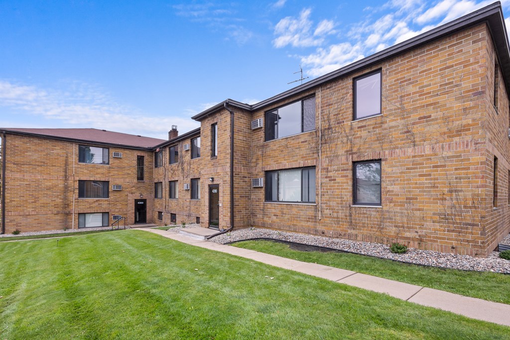 A brick building with a green lawn in front.