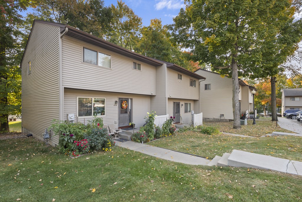 A beige house with a grey door and windows.