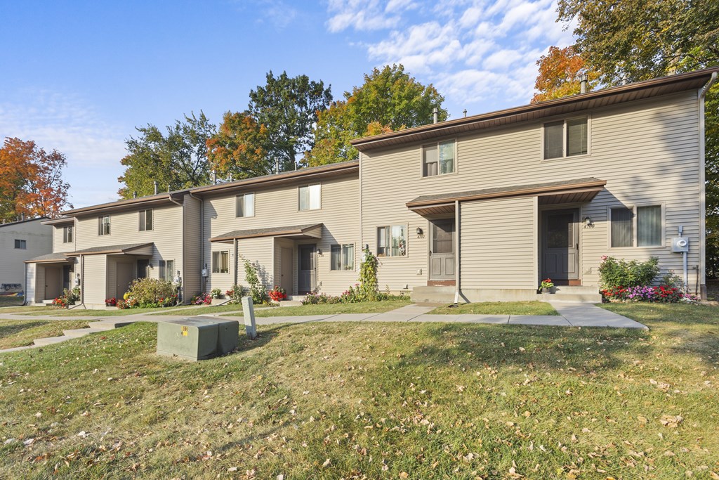 A row of houses with a grassy front yard.