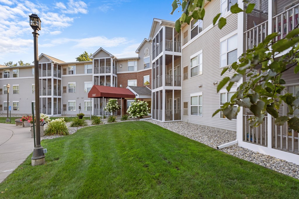 A large grassy area in front of apartment buildings.
