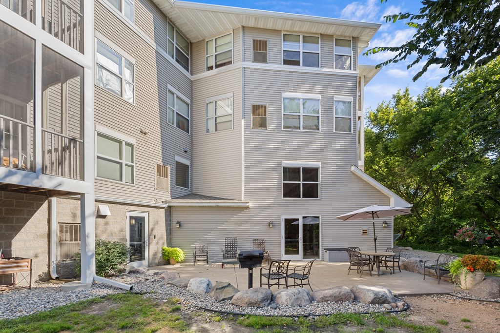 A modern apartment building with a patio and outdoor furniture.