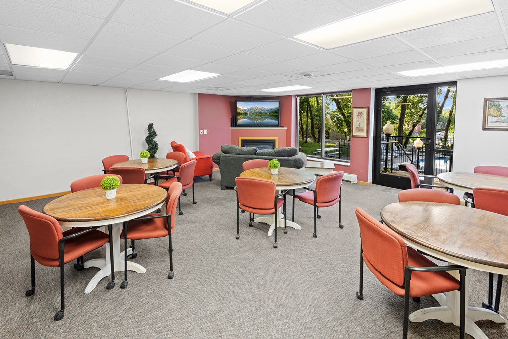 A conference room with a table surrounded by chairs.
