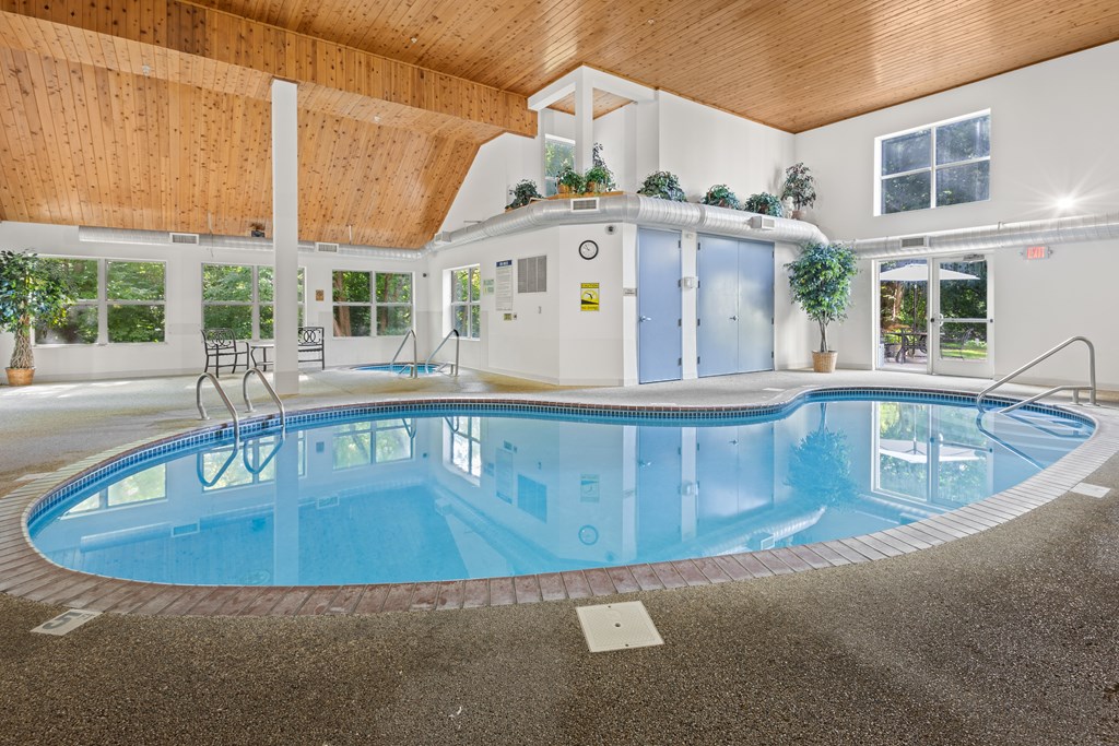 A large indoor swimming pool with a wooden ceiling.