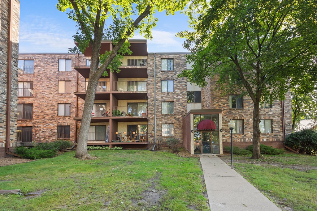 A brick building with a tree in front of it.