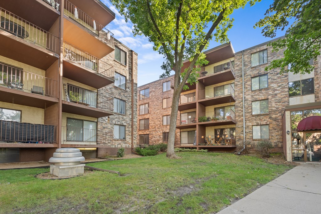A tree with yellow leaves is in front of a building.