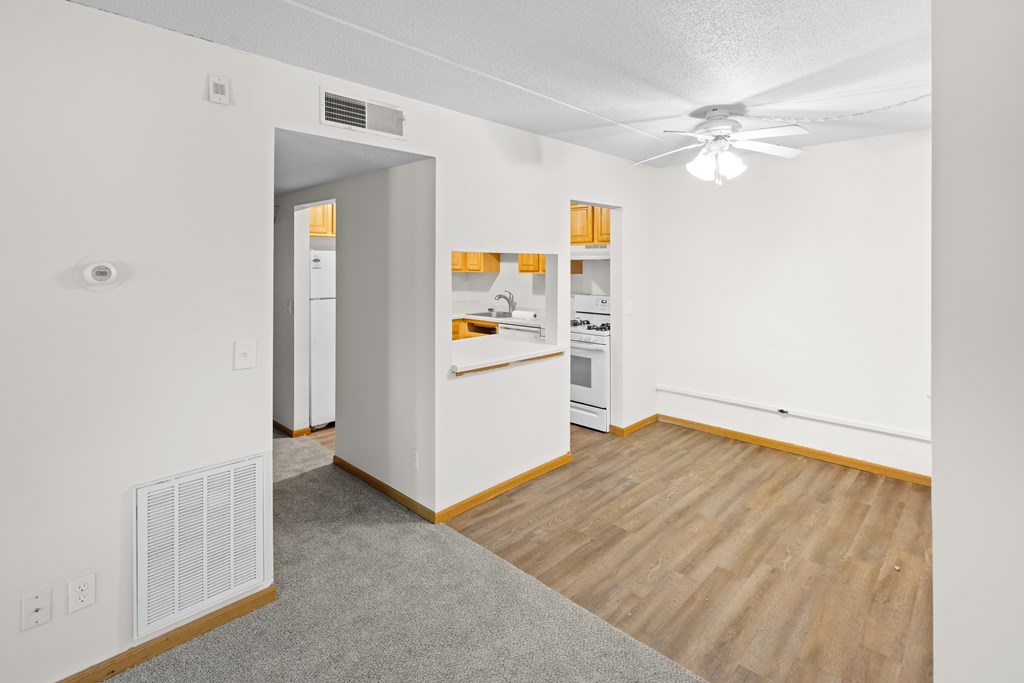 A kitchen with white cabinets and a wooden floor.