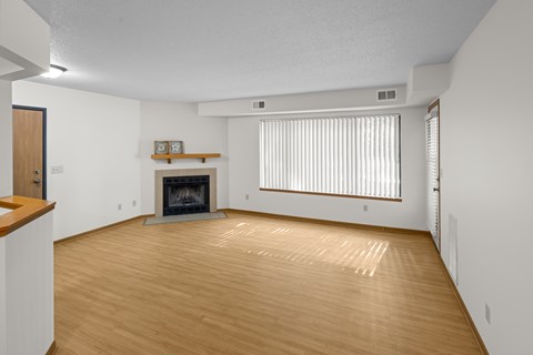 A living room with a fireplace and a wooden floor.