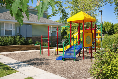 A playground with a yellow structure and a blue slide.