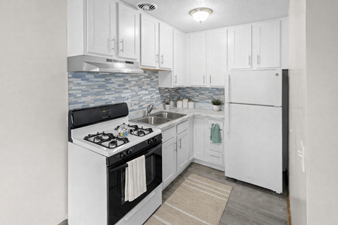 A kitchen with white cabinets and a black stove top oven.