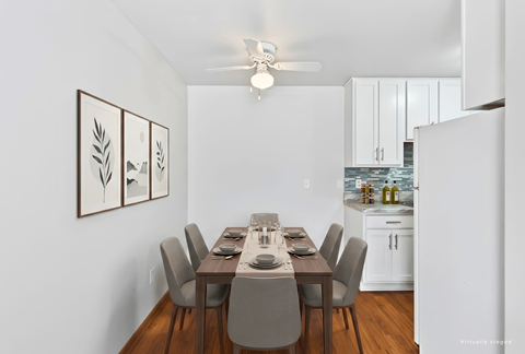 A dining room with a table set for six people.