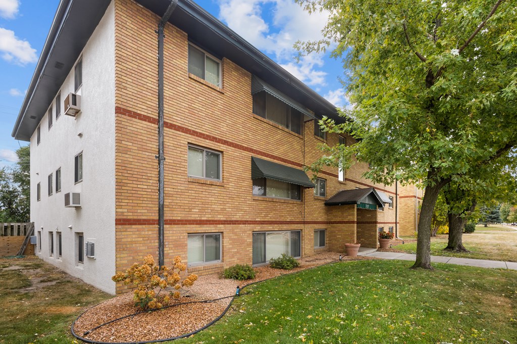 A brick house with a green lawn in front.