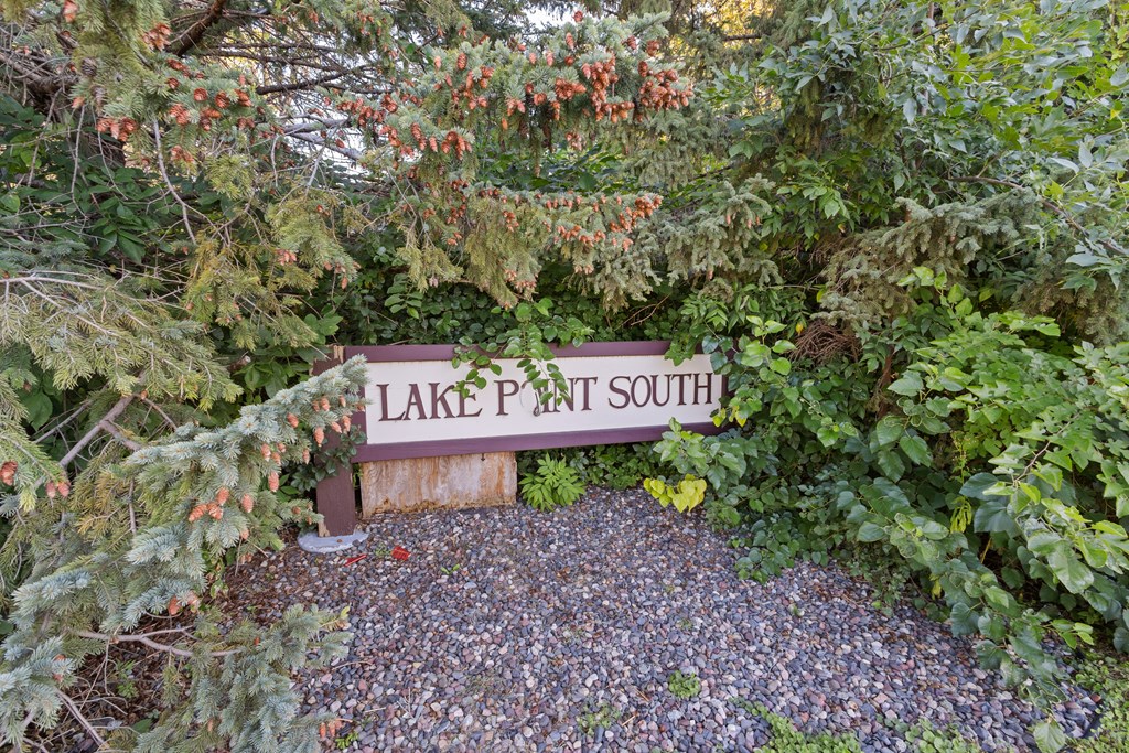 a sign for lake path south in front of some trees