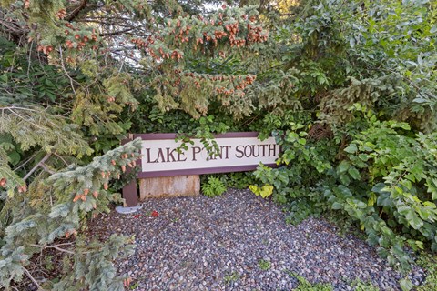A sign that says Lake Point South is surrounded by plants and gravel.