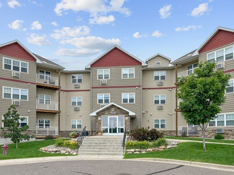 A large apartment complex with a front entrance and landscaping.