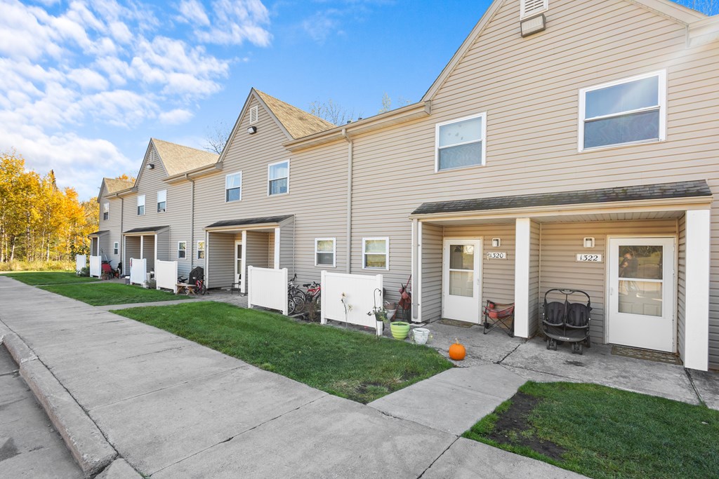 A row of houses with garages and front yards.