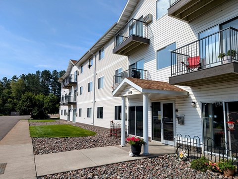 a view of the exterior of a building with a sidewalk and grass