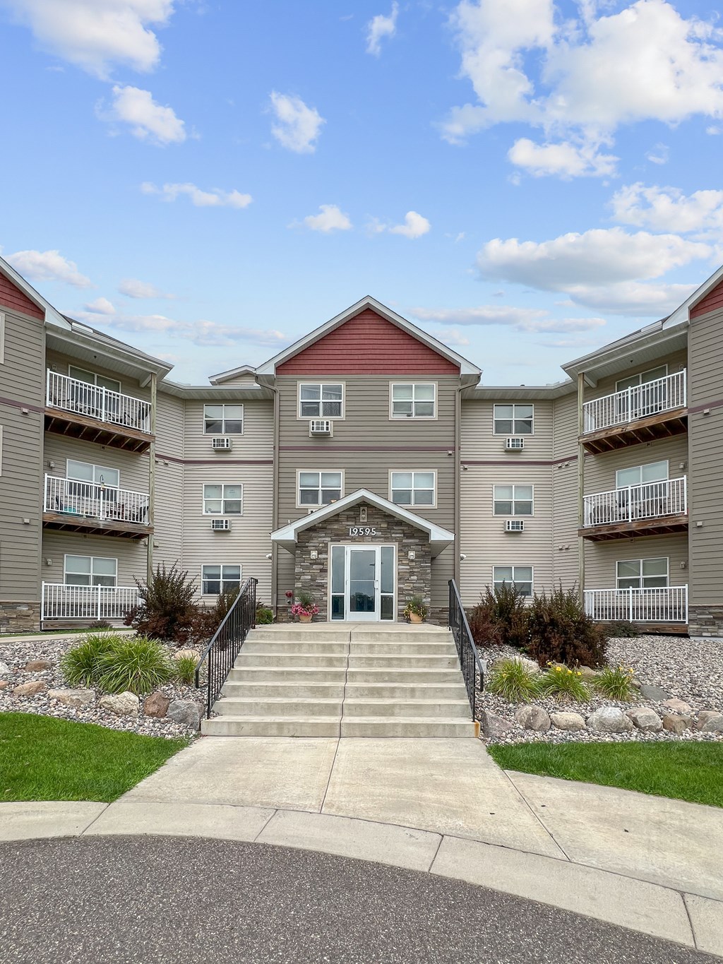 A building with a red roof and a front entrance with steps leading up to it.