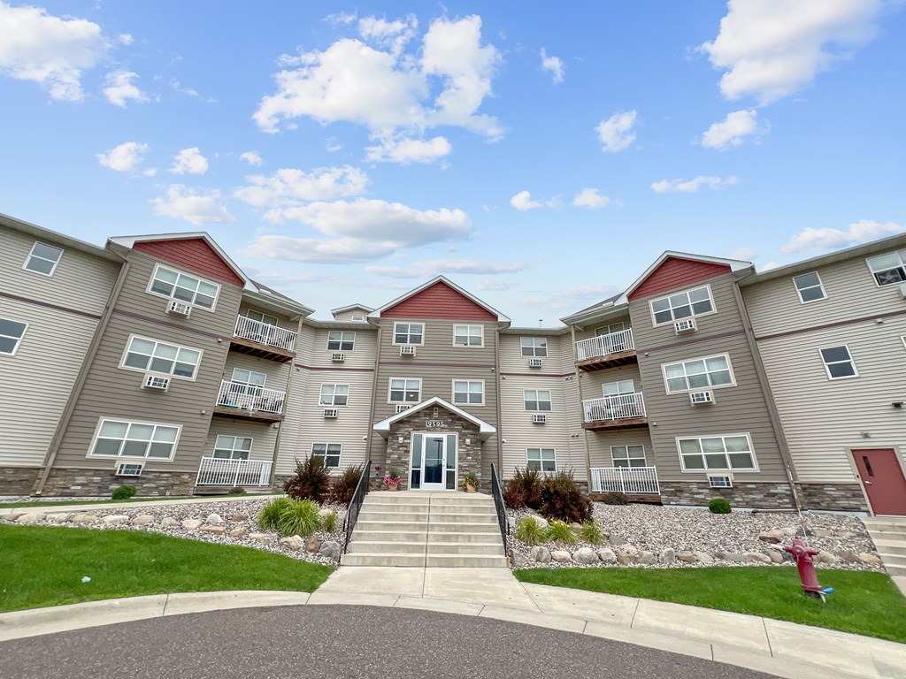 A large apartment complex with a red fire hydrant in front.