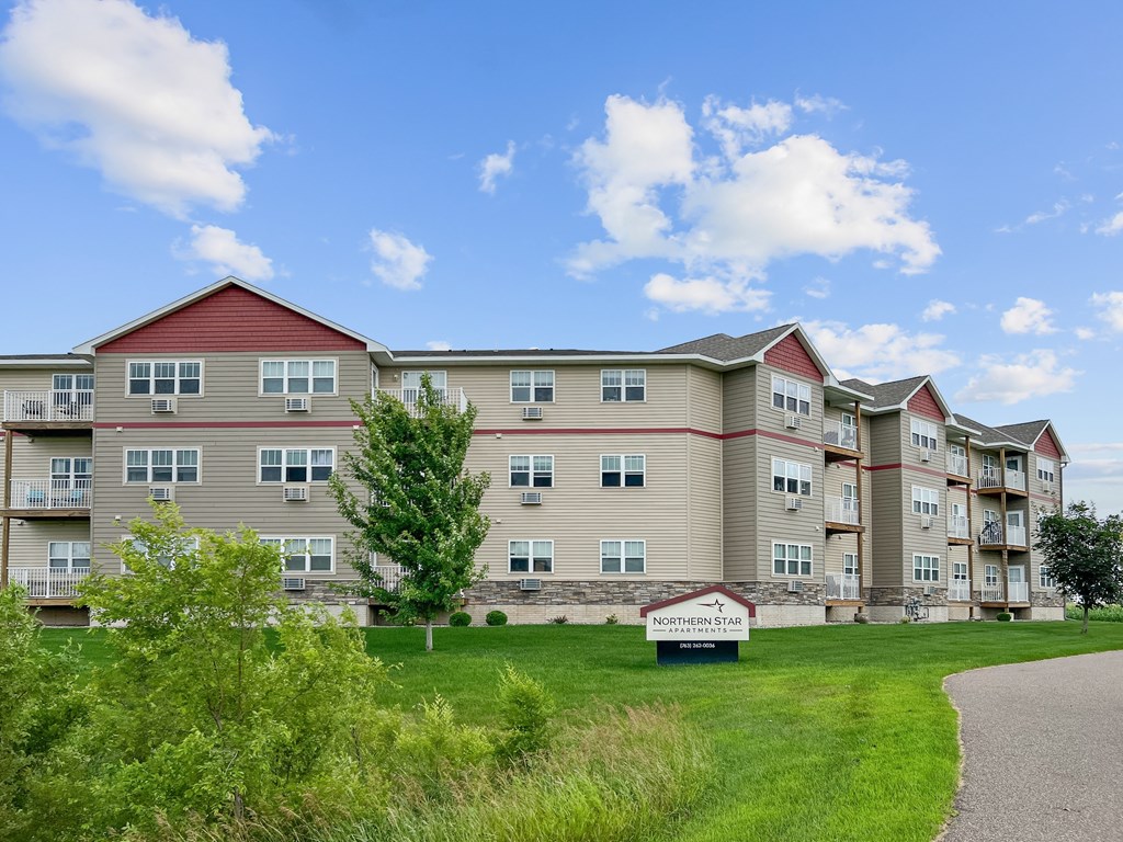 A large apartment complex named Northern Star is surrounded by green grass and trees.