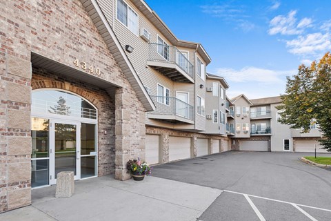 the entrance to an apartment building with an empty driveway