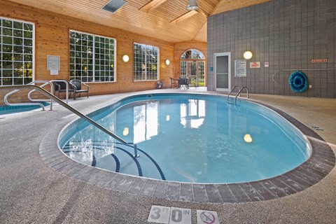 A round indoor swimming pool with a glass enclosure.