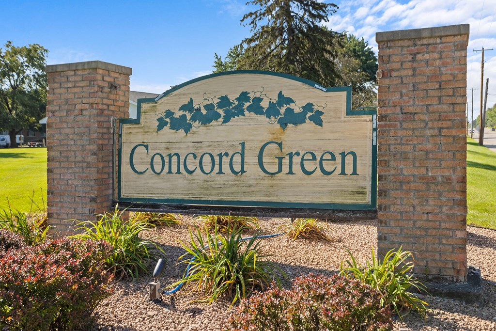 a sign for concord green in front of a park