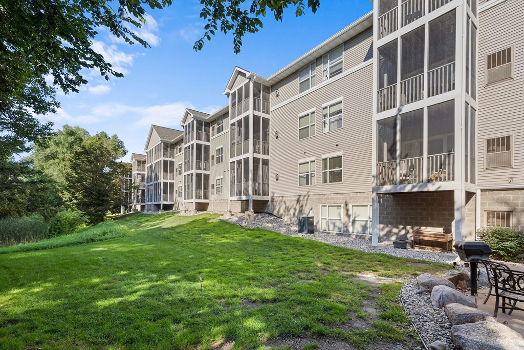 A large apartment complex with a grassy area in front.