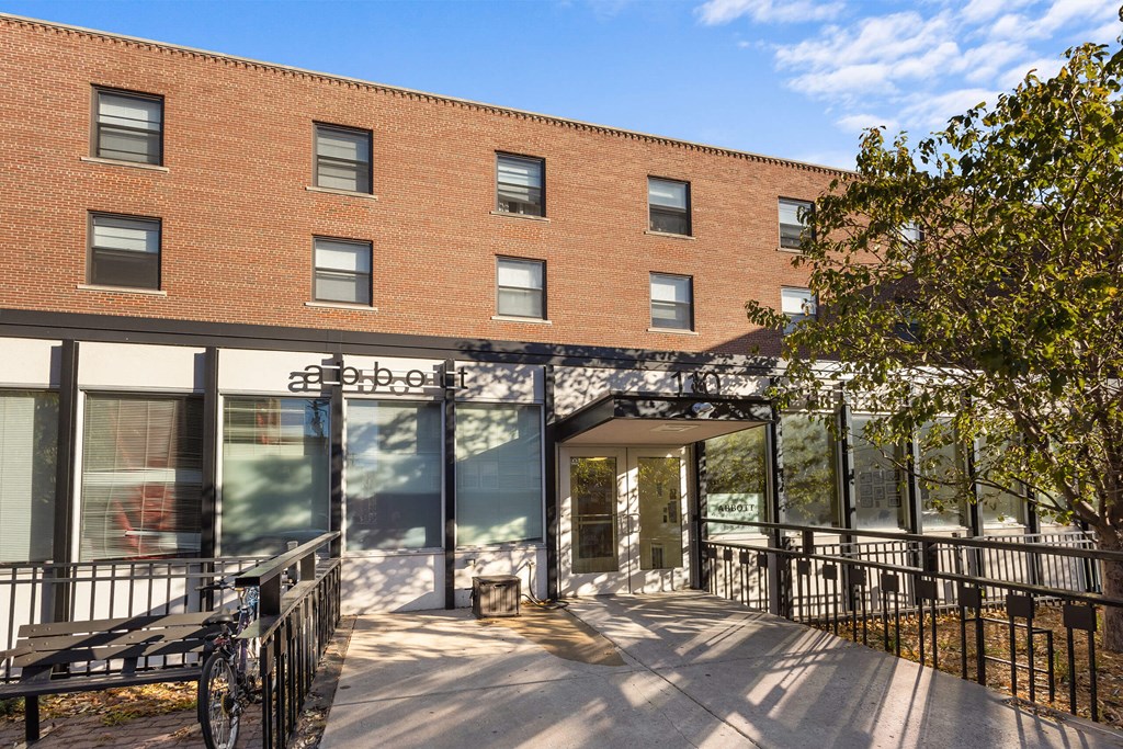 a large brick building with a patio and a bench