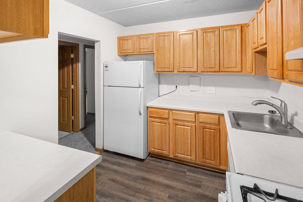 A kitchen with wooden cabinets and a white refrigerator.