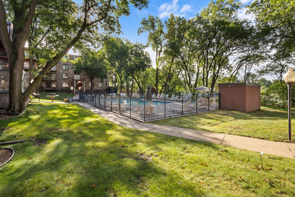 A sunny day in a park with a fence and a brown structure.