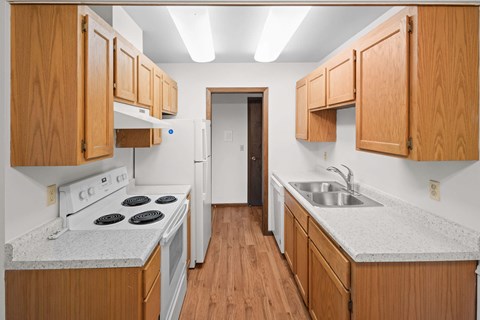 A kitchen with wooden cabinets and a white stove top oven.