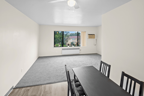 A dining room with a table and chairs.