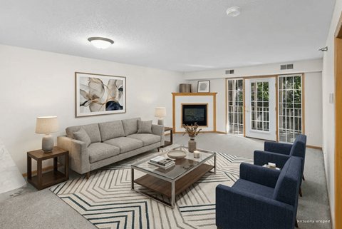 A living room with a grey couch, a coffee table, and a painting on the wall.