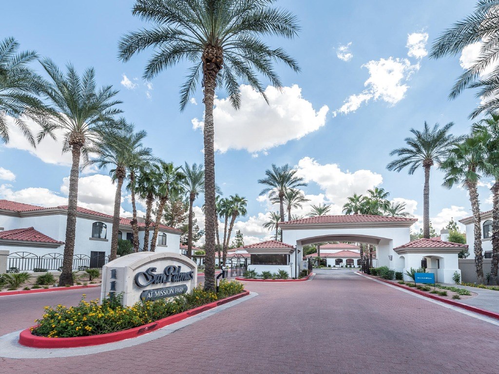 a view of the entrance to a resort building with palm trees