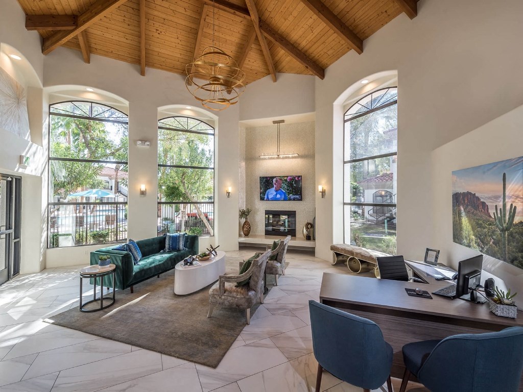 the living room has large windows and a vaulted ceiling