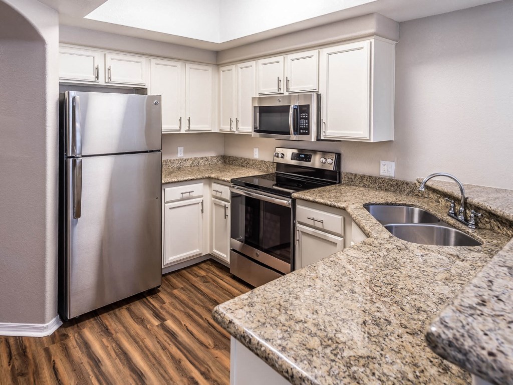 a kitchen with granite counter tops and stainless steel appliances