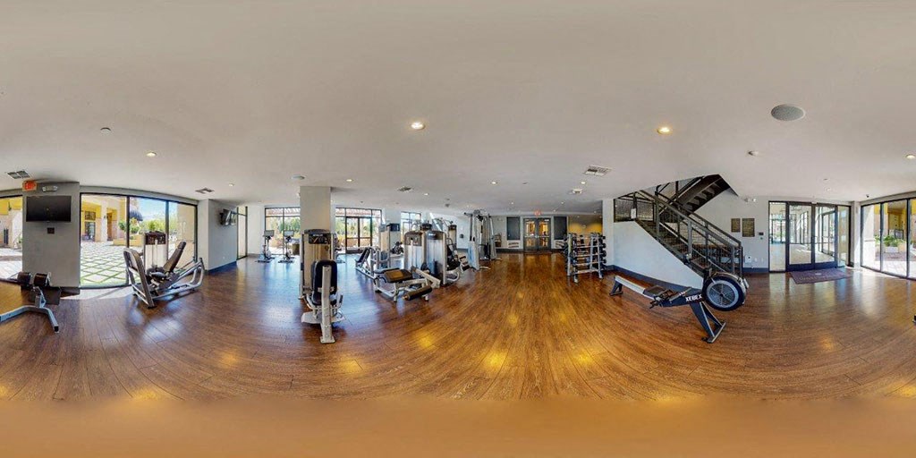 a gym with weights and cardio equipment in a large room