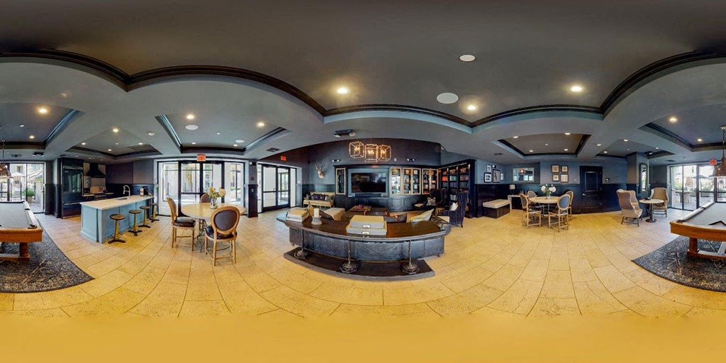 a large lobby with tables and chairs and a bar