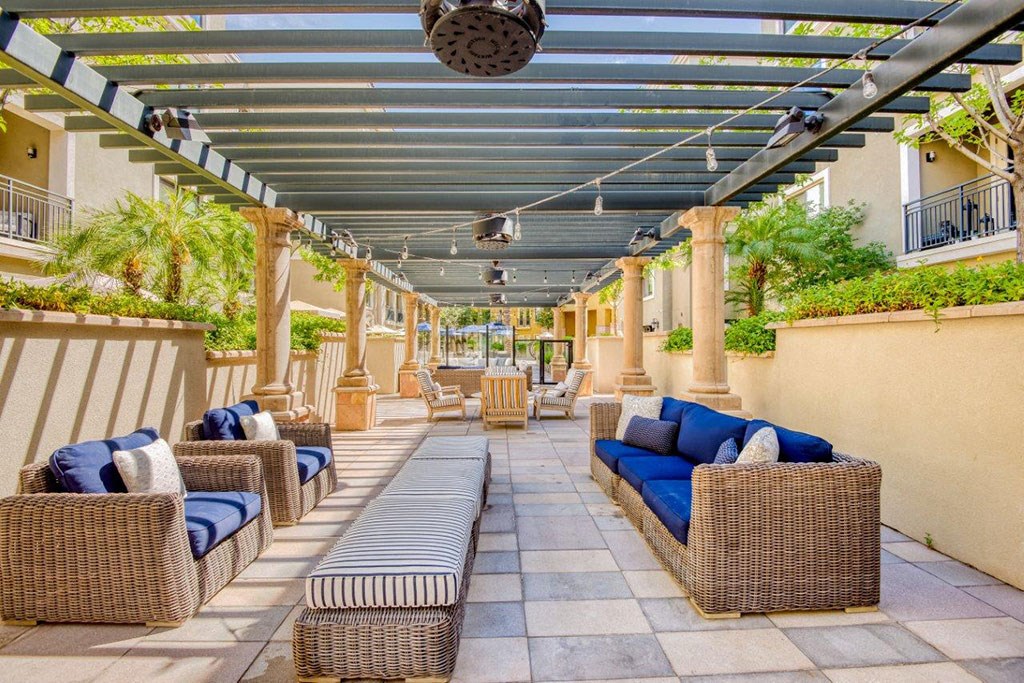 a patio with wicker furniture and a pergola