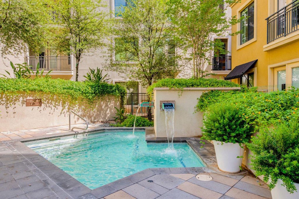 a swimming pool with a fountain in front of a building