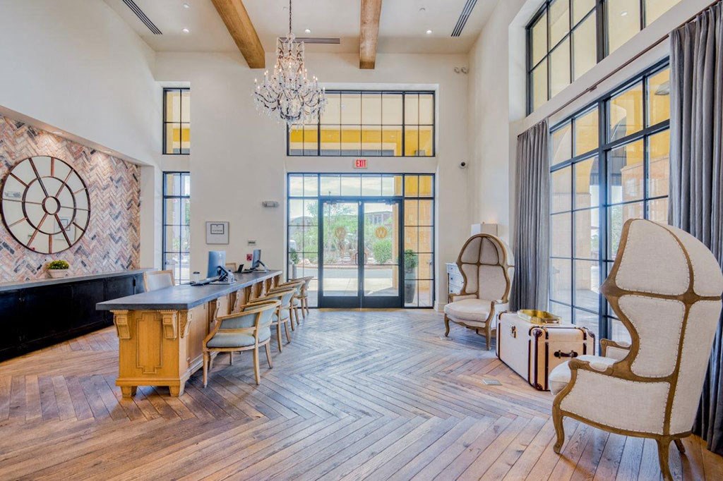 a dining room with a long table and chairs and large windows