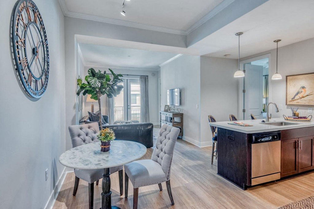 a dining room and kitchen with a large clock on the wall